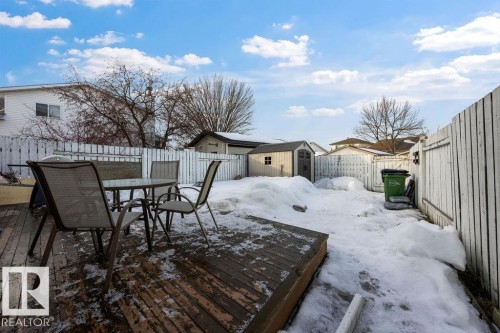 Snow covered deck with outdoor dining area, a storage unit, and a fenced backyard - 736 Johns Road, Edmonton, AB - Outdoor