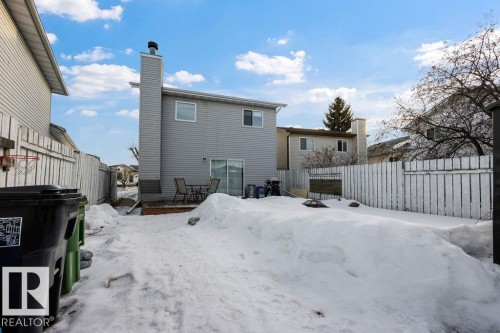 Snow covered rear of property with a fenced backyard and a chimney - 736 Johns Road, Edmonton, AB - Outdoor