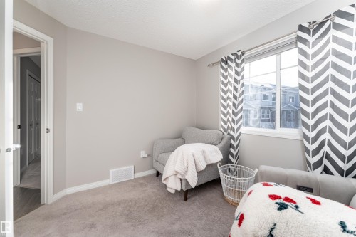 Bedroom featuring carpet floors and a textured ceiling - 8 7385 Edgemont Way, Edmonton, AB - Indoor Photo Showing Bedroom
