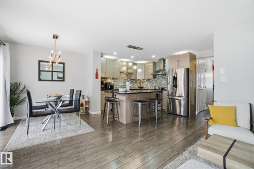 Living room with hanging lights and dark wood-style flooring - 64 2004 Grantham Court, Edmonton, AB - Indoor