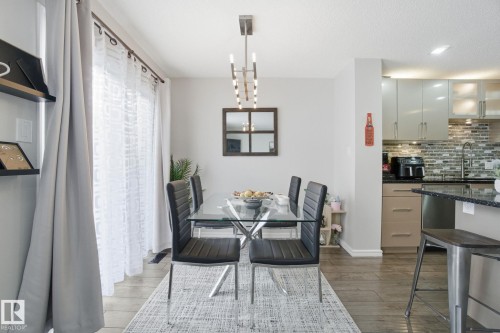 Dining space featuring suspended lighting and dark wood-style floors - 64 2004 Grantham Court, Edmonton, AB - Indoor Photo Showing Dining Room