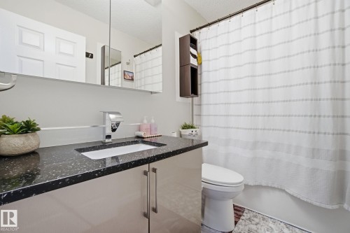 Bathroom with vanity, a textured ceiling, and shower / tub combo - 64 2004 Grantham Court, Edmonton, AB - Indoor Photo Showing Bathroom