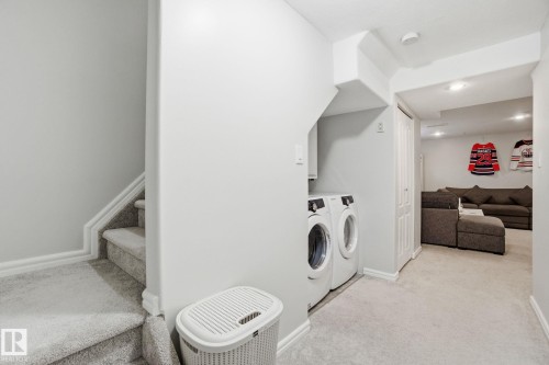 Laundry area featuring light colored carpet and washer and dryer - 64 2004 Grantham Court, Edmonton, AB - Indoor Photo Showing Laundry Room