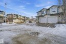 Snow covered property with a residential view, an attached garage, and driveway - 64 2004 Grantham Court, Edmonton, AB  - Outdoor With Facade 