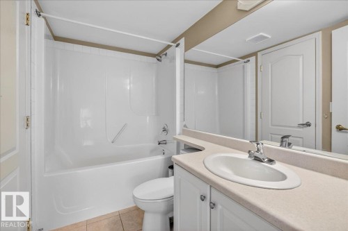 Bathroom with vanity, shower / bath combination, and light tile patterned flooring - 402 10649 Saskatchewan Drive, Edmonton, AB - Indoor Photo Showing Bathroom