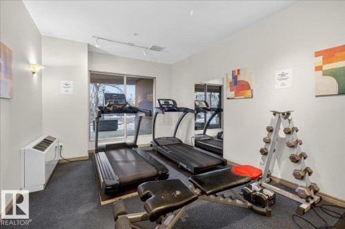 Workout area featuring track lighting and a wall mounted air conditioner - 402 10649 Saskatchewan Drive, Edmonton, AB - Indoor Photo Showing Gym Room
