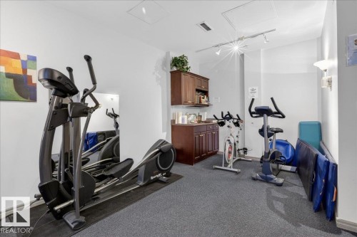 Exercise area featuring rail lighting and attic access - 402 10649 Saskatchewan Drive, Edmonton, AB - Indoor Photo Showing Gym Room