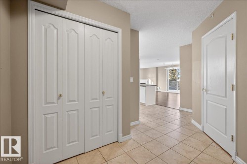 Hall featuring a textured ceiling and light tile patterned floors - 402 10649 Saskatchewan Drive, Edmonton, AB - Indoor Photo Showing Other Room