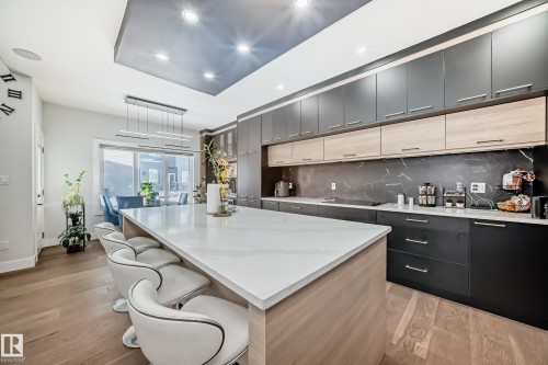 Two tone kitchen featuring two tone cabinetry, modern cabinets, and light wood-style floors - 17112 68 Street, Edmonton, AB - Indoor Photo Showing Kitchen