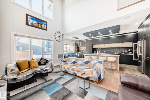 Living room featuring light wood-type flooring and a high ceiling - 17112 68 Street, Edmonton, AB - Indoor