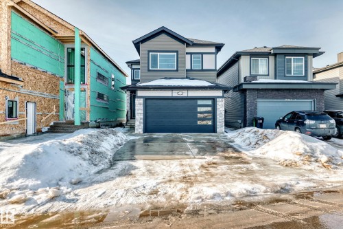 View of front of property with an attached garage, driveway, and stone siding - 17112 68 Street, Edmonton, AB - Outdoor With Facade