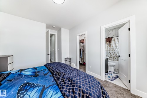 Carpeted bedroom with a spacious closet and ensuite bath - 17112 68 Street, Edmonton, AB - Indoor Photo Showing Bedroom