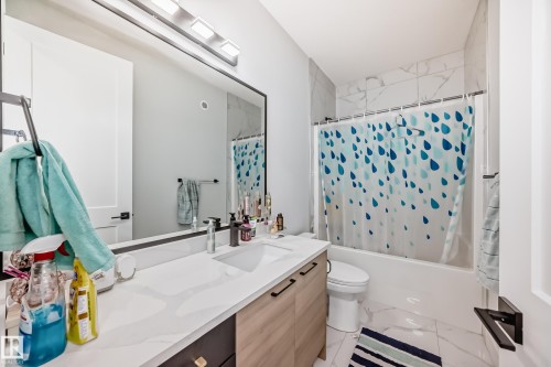 Bathroom with vanity, shower / bath combination with curtain, and light marble finish flooring - 17112 68 Street, Edmonton, AB - Indoor Photo Showing Bathroom