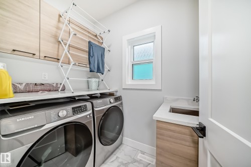 Laundry area with cabinet space, washer and clothes dryer, and marble finish flooring - 17112 68 Street, Edmonton, AB - Indoor Photo Showing Laundry Room