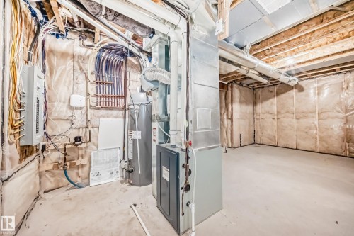 Unfinished basement featuring water heater, heating unit, and electric panel - 17112 68 Street, Edmonton, AB - Indoor Photo Showing Basement