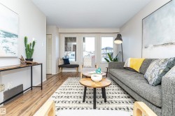 Living room with a textured ceiling and light wood-style flooring - 