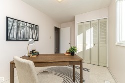 Office with a textured ceiling and light colored carpet - 