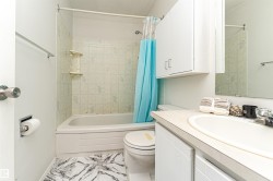 Bathroom featuring vanity, shower / tub combo, and marble look tile flooring - 