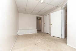 Unfurnished room featuring a drop ceiling and light colored carpet - 