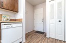 Kitchen with white dishwasher, a textured ceiling, dark wood finished floors, and brown cabinets - 8660 27 Avenue, Edmonton, AB  - Indoor Photo Showing Other Room 