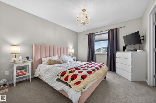 Bedroom featuring carpet flooring and a chandelier - 5256 21 Avenue, Edmonton, AB - Indoor Photo Showing Bedroom