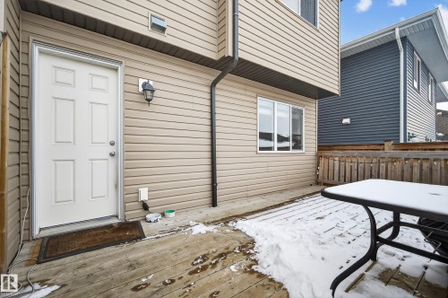 Snow covered property entrance with a wooden deck - 5256 21 Avenue, Edmonton, AB - Outdoor With Deck Patio Veranda With Exterior
