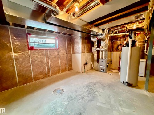 Below grade area with water heater and heating unit - 5256 21 Avenue, Edmonton, AB - Indoor Photo Showing Basement