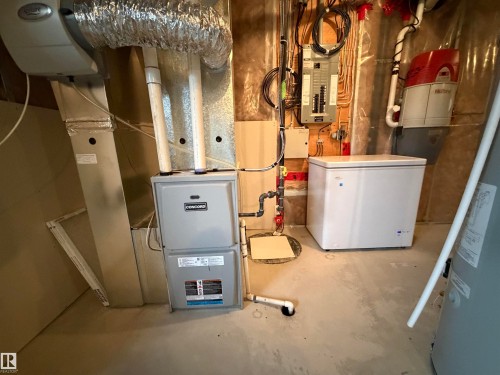 Utilities featuring electric panel and water heater - 5256 21 Avenue, Edmonton, AB - Indoor Photo Showing Basement