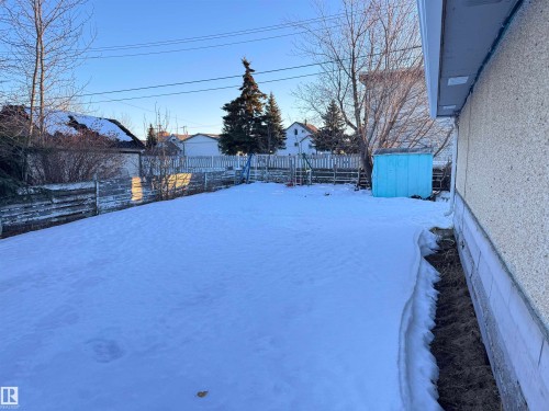 Yard layered in snow with a fenced backyard and a an old metal shed - 10407 102 Street, Westlock, AB - Outdoor