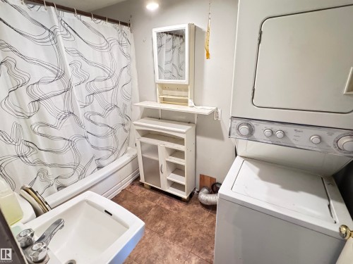 Washroom with stacked washer / drying machine - 10407 102 Street, Westlock, AB - Indoor Photo Showing Laundry Room