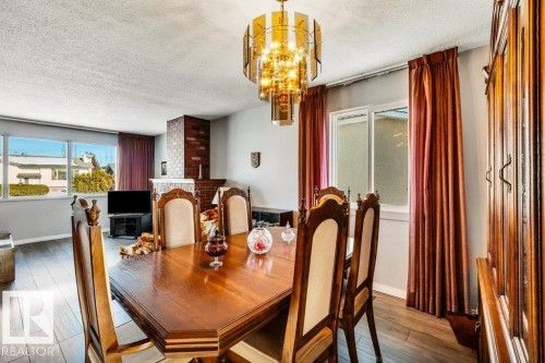 Dining area featuring a textured ceiling, hardwood / wood-style flooring, and a chandelier - 8919 152A Avenue, Edmonton, AB - Indoor Photo Showing Dining Room