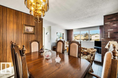 Dining area with a textured ceiling, wood finished floors, and a chandelier - 8919 152A Avenue, Edmonton, AB - Indoor Photo Showing Dining Room