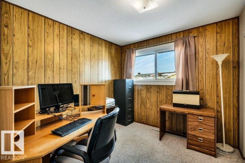 Office area with light colored carpet, wooden walls, and a textured ceiling - 8919 152A Avenue, Edmonton, AB - Indoor Photo Showing Office