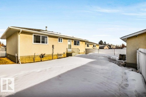 Snow covered back of property with a fenced backyard and stucco siding - 8919 152A Avenue, Edmonton, AB - Outdoor