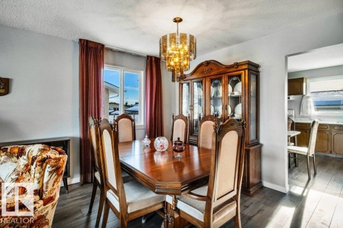 Dining area featuring a chandelier, dark wood-type flooring, and a textured ceiling - 8919 152A Avenue, Edmonton, AB - Indoor Photo Showing Dining Room