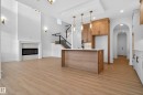 Kitchen featuring arched walkways, open floor plan, a high ceiling, pendant lighting, and light wood finished floors - 26 Rosa Crescent, St. Albert, AB  - Indoor Photo Showing Kitchen With Fireplace 