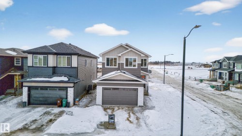 View of front of house featuring a residential view, a garage, and board and batten siding - 26 Rosa Crescent, St. Albert, AB - Outdoor With Facade