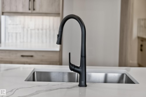Kitchen view of a sink and light stone countertops - 26 Rosa Crescent, St. Albert, AB - Indoor Photo Showing Kitchen With Double Sink
