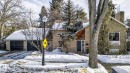 View of front of home featuring a chimney, driveway, brick siding, and a garage - 10235 134 Street Nw, Edmonton, AB 