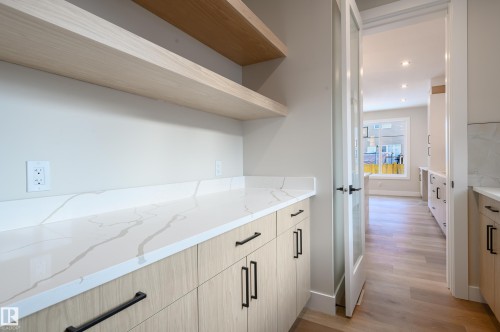 Kitchen with light stone counters, light wood finish cabinetry, open shelves, light wood-style flooring, and recessed lighting - 16 Middleton Close, Leduc, AB - Indoor