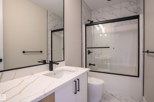 Bathroom with marble finish flooring, bath / shower combo with glass door, and vanity - 16 Middleton Close, Leduc, AB - Indoor Photo Showing Bathroom