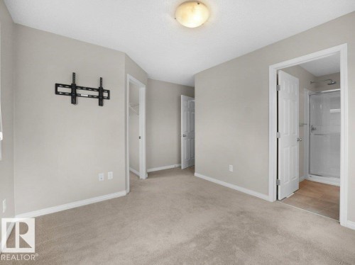 Unfurnished bedroom with light colored carpet and ensuite bath - 15 7385 Edgemont Way, Edmonton, AB - Indoor Photo Showing Other Room