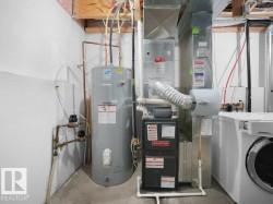 Utility room featuring washer / clothes dryer, electric water heater, and heating unit - 