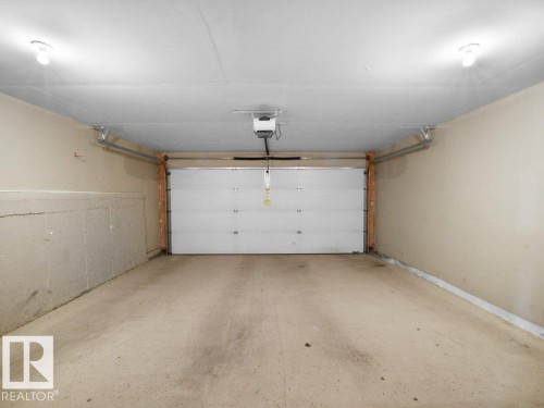 Garage with a garage door opener - 15 7385 Edgemont Way, Edmonton, AB - Indoor Photo Showing Garage