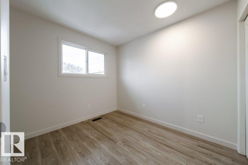 Empty room with light wood finished floors and baseboards - 13833 24 Street, Edmonton, AB - Indoor Photo Showing Other Room