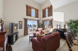 Living room featuring light colored carpet and a high ceiling - 