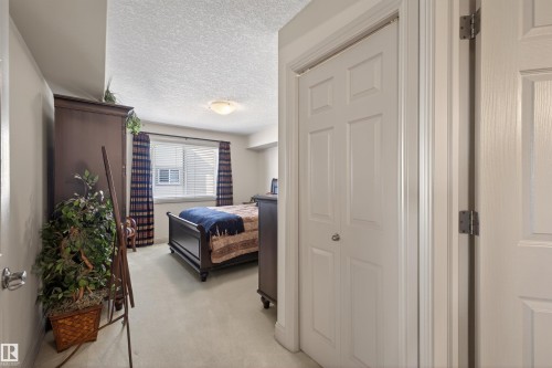 Bedroom featuring a textured ceiling and light carpet - 427 13005 140 Avenue, Edmonton, AB - Indoor