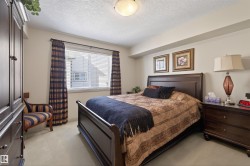 Bedroom with light colored carpet and a textured ceiling - 