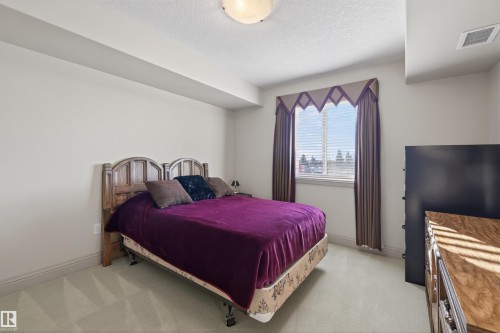 Bedroom featuring light carpet and a textured ceiling - 427 13005 140 Avenue, Edmonton, AB - Indoor Photo Showing Bedroom