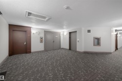 Spare room featuring elevator, a textured ceiling, and dark carpet - 